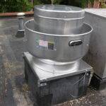 A commercial upblast exhaust fan installed by AireCom on the roof of a restaurant